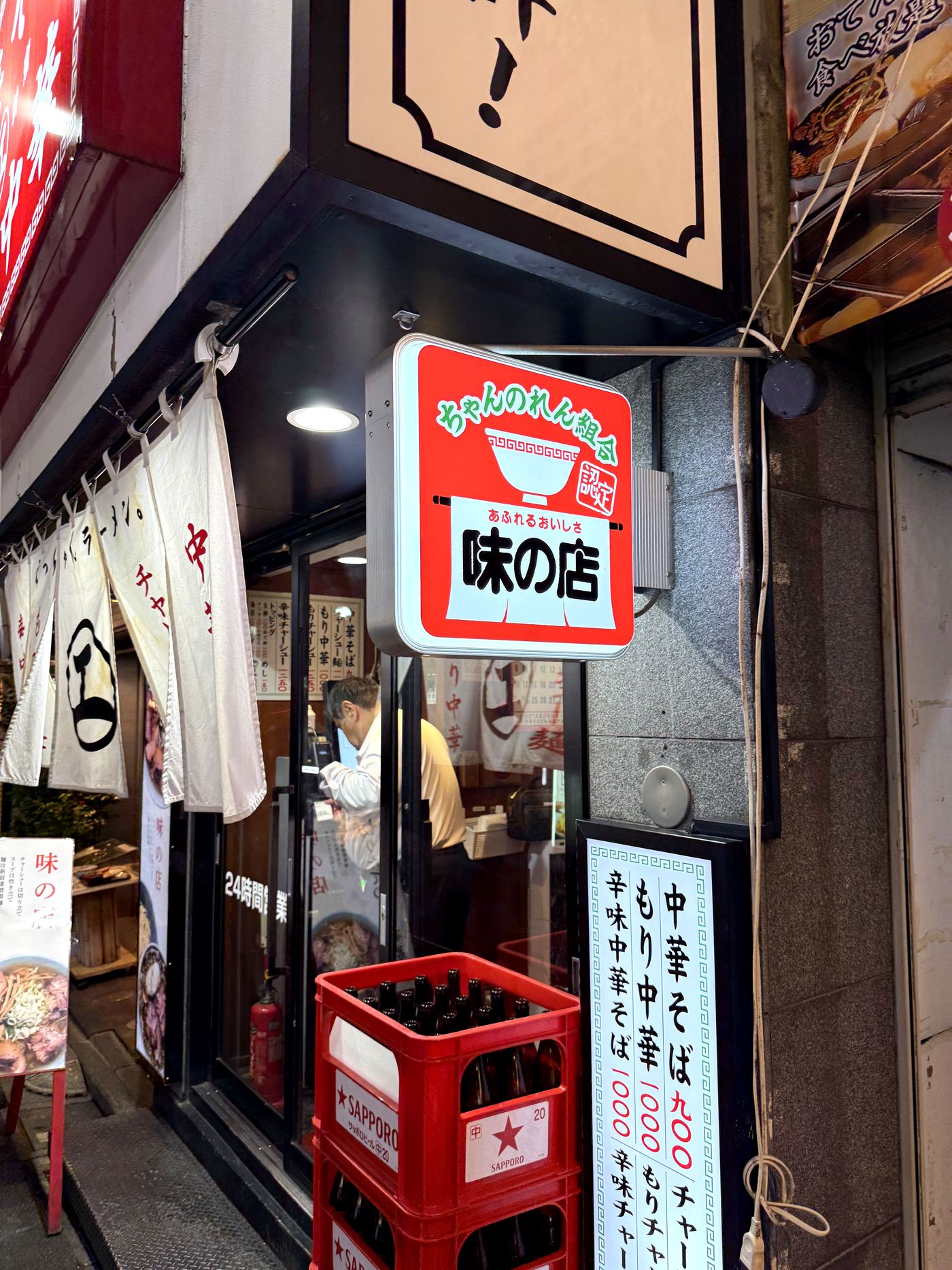 えっちゃんラーメン。の入り口にかかる「味の店」の丸い看板と暖簾