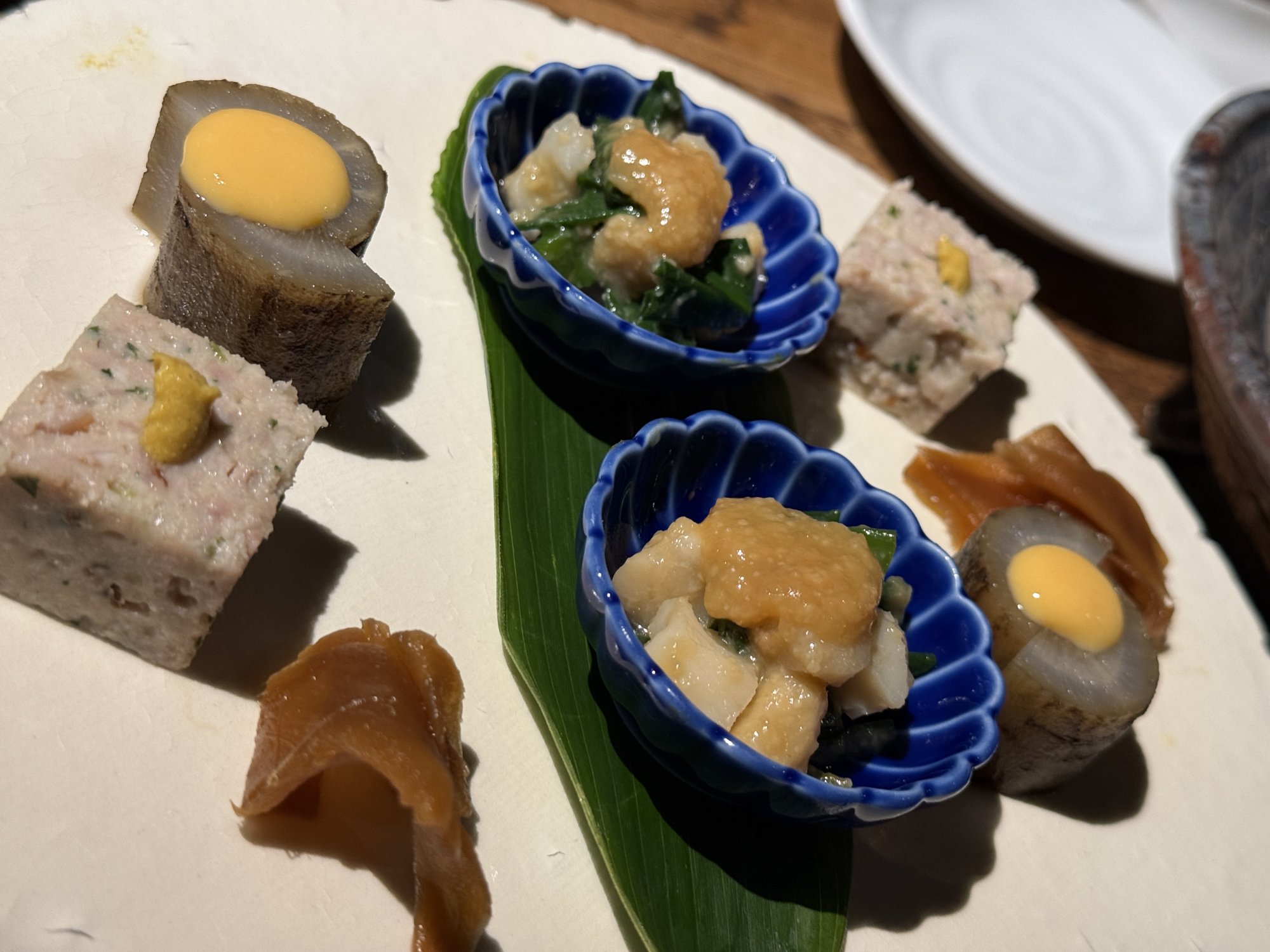 おつまみ三品の盛り合わせ。小鉢に三種類の料理が美しく盛り付けられている