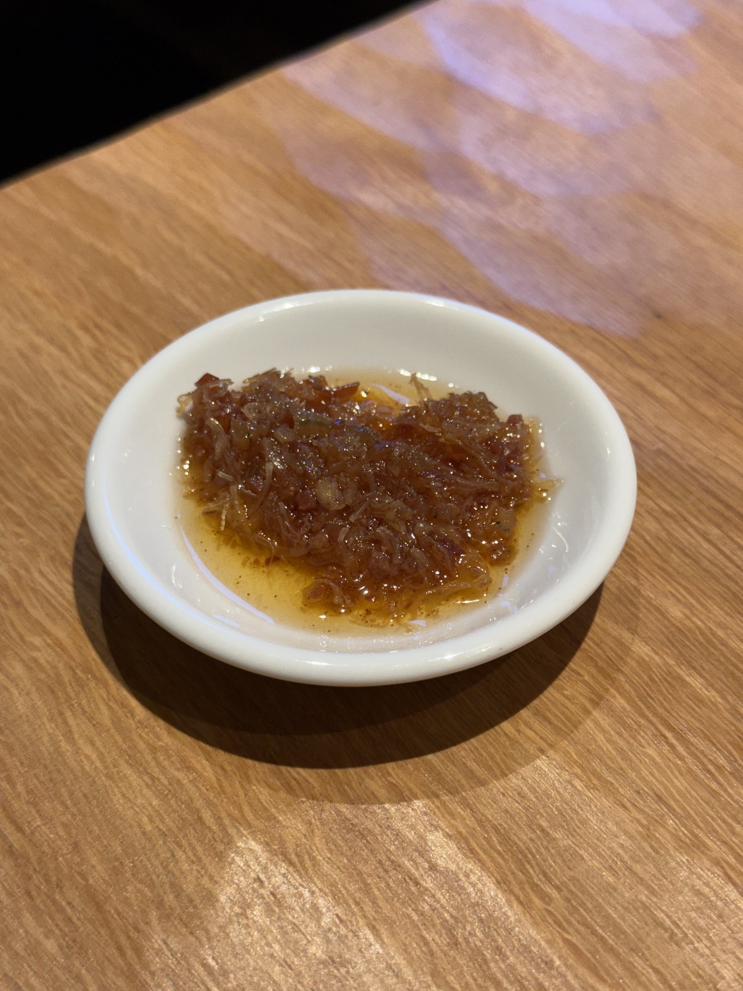 新楽記のお通し。小皿に盛られた薬味と醤油だれの小鉢
