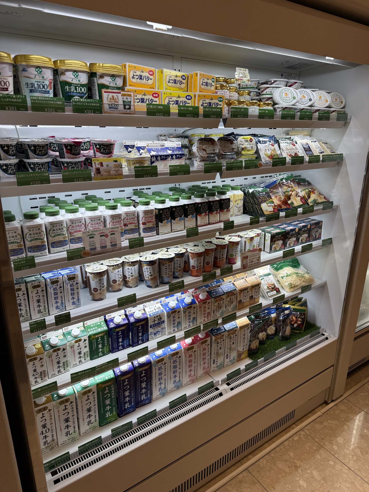 よつ葉のバター、ヨーグルト、チーズが並ぶ乳製品売り場の冷蔵ケース