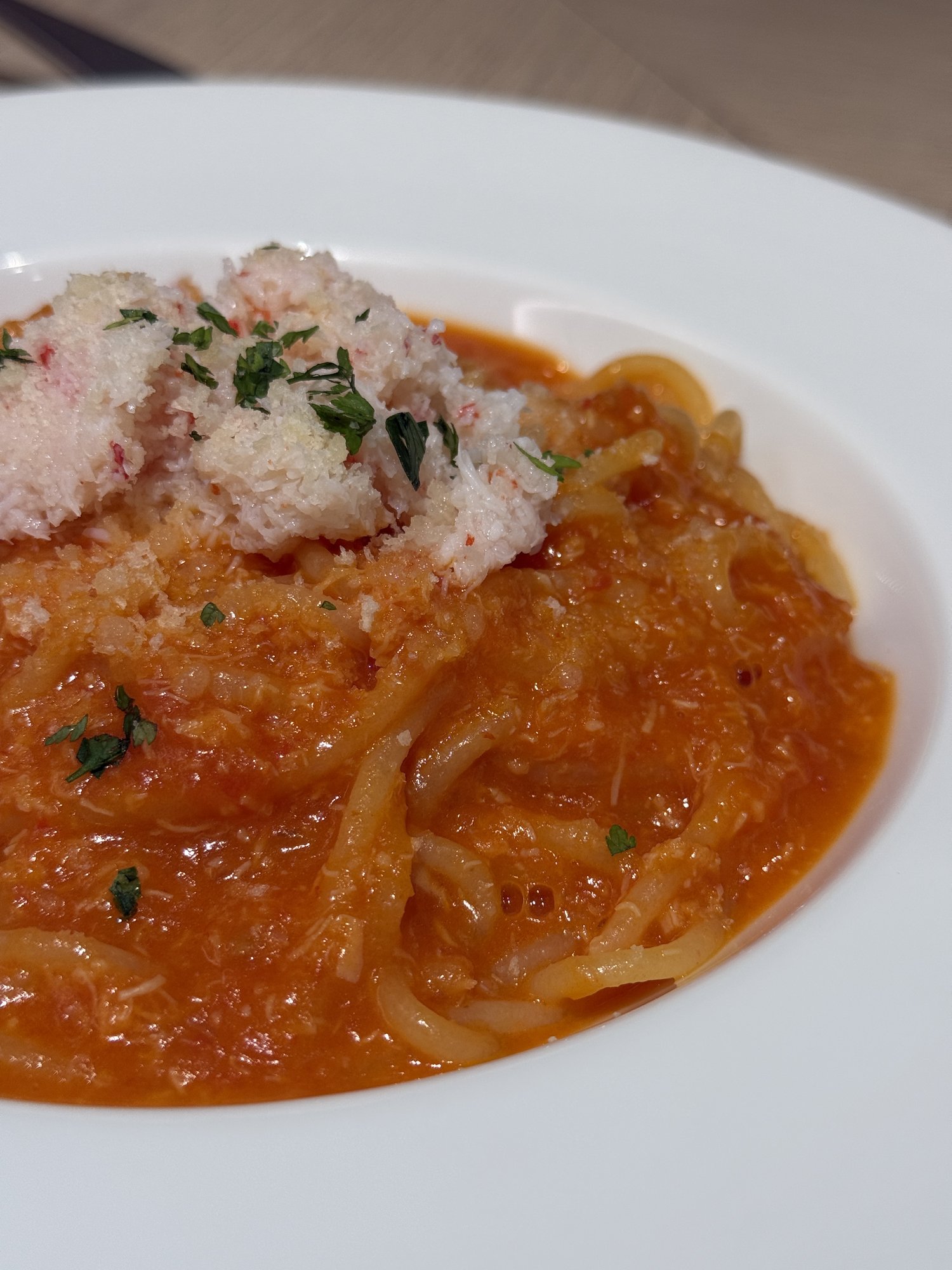蟹の身がたっぷり乗ったトマトソースパスタのアップ