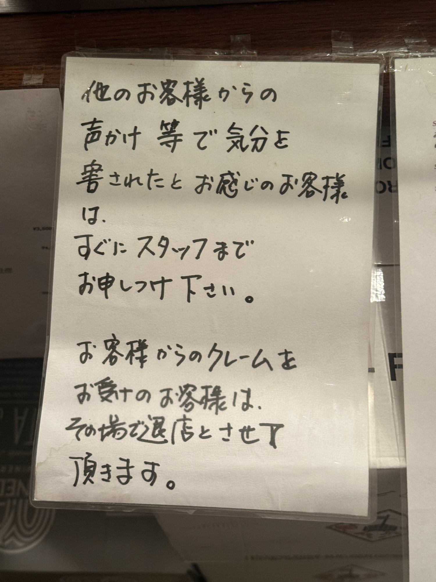 「他のお客様からの声かけ等で気分を害された場合はスタッフへ」と書かれた張り紙